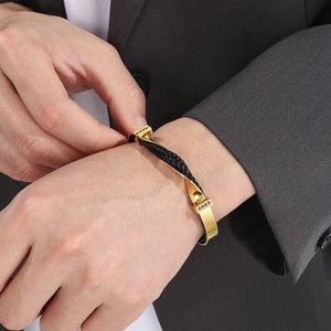 Men's gold and black twisted steel cable bracelet with pavé black stones on male wrist