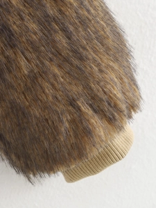 Detailansicht der braunen Pelzmanschette mit khakifarbenem Rippstrick am Ärmelbund