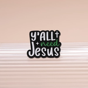 Enamel brooch with 'Y'ALL need Jesus' text and cross on a striped display stand