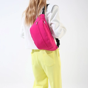Borsone da petto fucsia capiente indossato come elegante borsa a tracolla marsupio