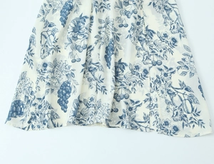 Detailed view of the lightweight floral fabric with grape and cherry prints on white base