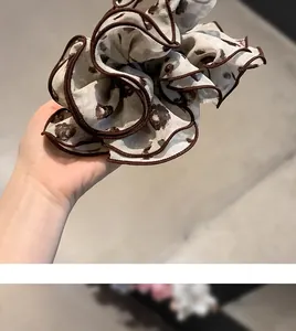 Detail of a large chiffon floral scrunchie with contrast brown piping in Korean style