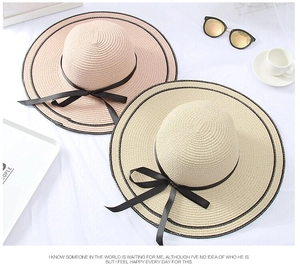 Detail view of woven straw sun hats with black bows and summer vacation accessories