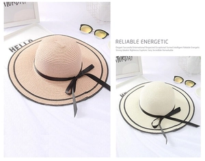 Detail of wide brim straw hats with black ribbon bows in pink and beige colors