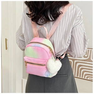 Tie-dye gradient mini backpack in pink and purple with a plush white ball charm detail