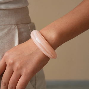 Detailed close-up of a pink marble resin bangle with a polished geometric glossy surface