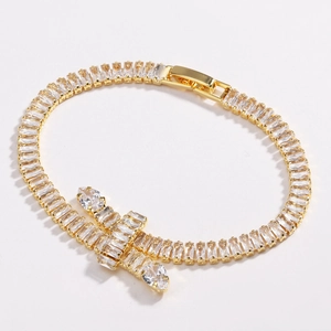 Macro detail of gold tennis bracelet featuring step-cut white cubic zirconia crystals
