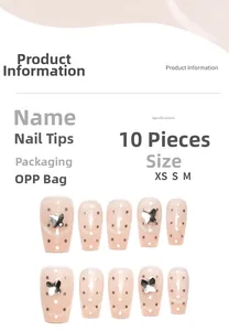 Detail view of pink nude cat-eye press-on nails with white dots and silver butterfly charms