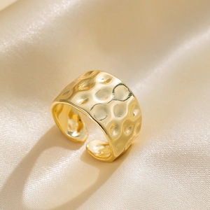 Minimalist gold hammer-textured wide open ring on elegant champagne satin background