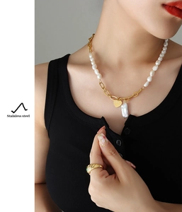 Detail of 18K gold plated heart pendant with LOVE engraving and freshwater pearls