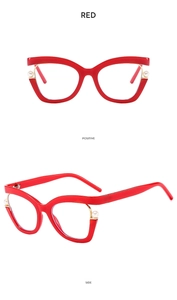 Detail of red cat-eye glasses frame featuring elegant pearl accents on temple hinges
