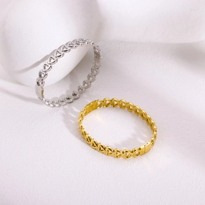 Elegant gold and silver stainless steel bangles with hollow heart design on white background
