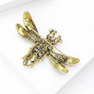 Back view of a gold vintage dragonfly brooch showing the safety pin clasp mechanism