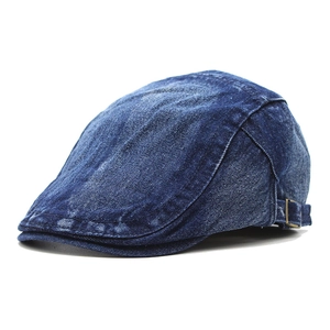 Detail of blue washed denim ivy cap featuring neat stitching and adjustable bronze buckle
