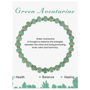 Macro view of green aventurine bead bracelet with gold spacers on healing card