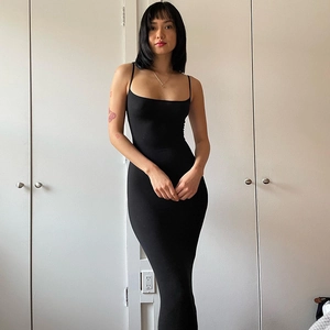 Detail of a black backless slim-fit maxi dress featuring a high-slit and soft jersey fabric