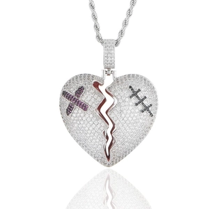 Détail macro du pendentif cœur brisé avec croix violette et cristaux sur chaîne torsadée