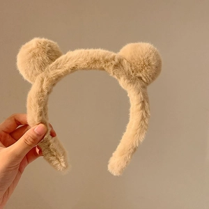 Detail view of khaki plush headband with cute bear ears for facial cleansing and makeup