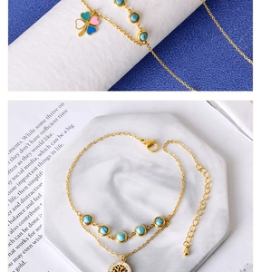 Detailed view of golden jewelry set featuring clover pendants and a tree of life charm