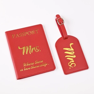 Close-up of red PU leather passport holder and luggage tag with gold Mrs. lettering