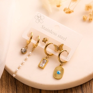 Detail of assorted golden stainless steel earrings including pearl and zircon pendants