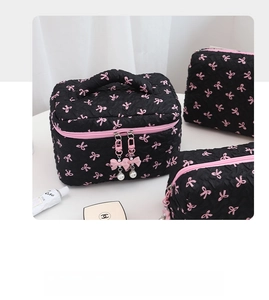 Detailed set of black cosmetic bags with pink bow patterns and pearl zipper charms