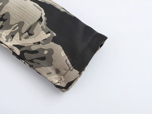 Detail of elegant retro jacquard puff sleeve showing black cuff and intricate fabric texture