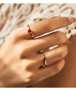 Close-up of gold and silver plated s925 silver rings with round red opal gemstones