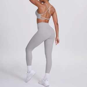 Vue arrière de l'ensemble de yoga gris clair avec brassière croisée et legging galbant