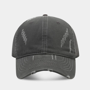 Detail of distressed ripped cotton baseball cap in charcoal gray with vintage finish