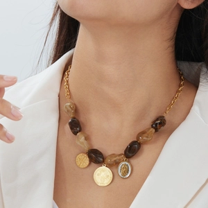Close-up of vintage beaded necklace set with embossed gold pendants on a model