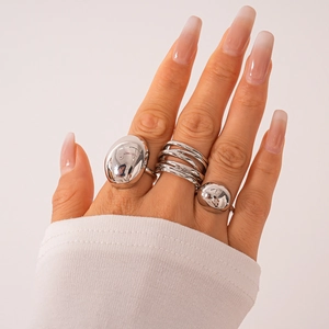Detailed view of silver geometric ring set with domed and multi-layer coiled metal bands