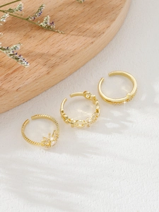 Detailed view of three-piece gold adjustable ring set with star zircon and chain designs