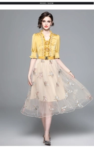 Detail of dragonfly embroidery on beige tulle skirt with yellow ruffled top set