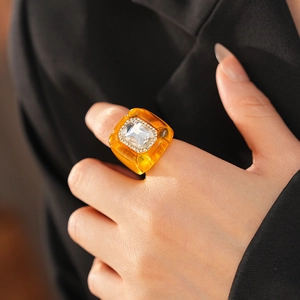 Gros plan d'une bague en résine ambrée ornée d'un grand cristal rectangulaire brillant