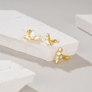 Close-up of gold S925 silver stud earrings with devil's eye opal and sparkling crystals