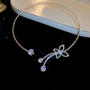 Silver open choker necklace featuring crystal flower and tassel on dark background