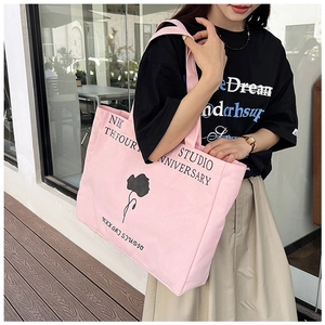 Pink canvas tote bag with black flower print and lettering for casual daily wear