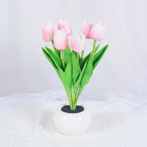 Detailed view of pink LED tulip night light in white ceramic vase on lace cloth