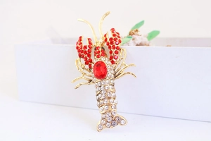Detailed macro view of crystal lobster charm with red rhinestones and gold alloy base