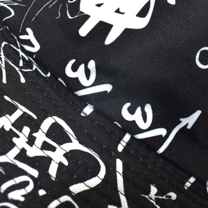 Close-up of durable black bucket hat canvas with white letter print and reinforced stitching