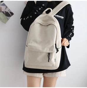 Close-up of durable canvas backpack in beige featuring functional side and front pockets