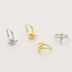 Minimalist S925 silver knot earrings in gold and silver finishes on beige background