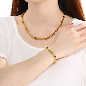 Ensemble collier et bracelet dorés avec fermoir OT minimaliste porté par un mannequin