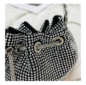 Macro view of black velvet bucket bag with silver rhinestones and metal chain detail