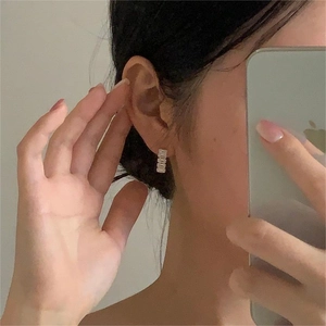 Close-up of minimalist S925 silver stud earrings featuring five rectangular zircons