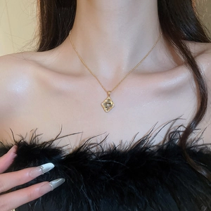 Detail of a vintage-style gold plated diamond floral necklace worn on a woman's collarbone