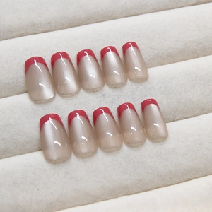 Cat eye press-on nails with red French tips and champagne glitter in a square oval shape