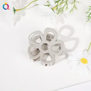 Detail view of flower-shaped hair claw clip in beige resin with hollow petal design