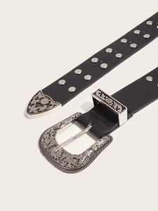 Detailed view of western style belt with floral engraved buckle and silver rivets